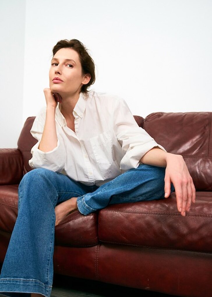 Woman seated on a leather sofa &mdash; menopause treatment at Evolved Medical