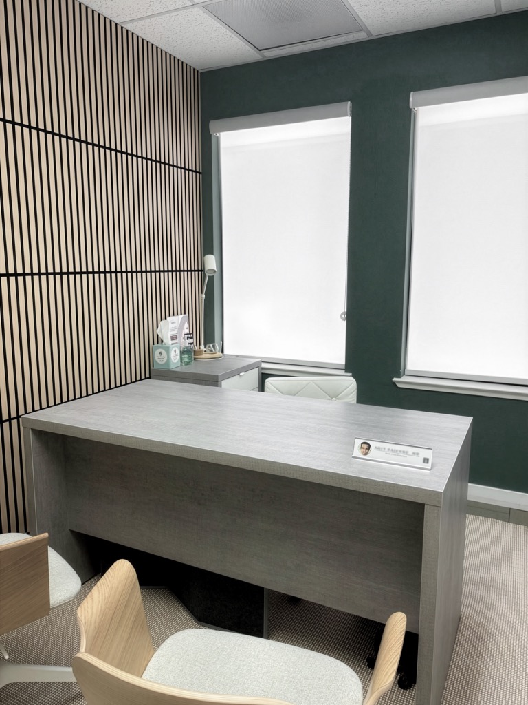 Evolved Medical consultation office with a grey desk and slatted wood wall
