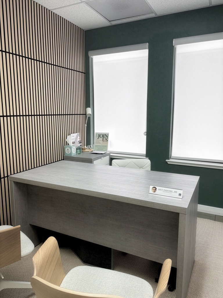 Evolved Medical consultation office with a grey desk and slatted wood wall