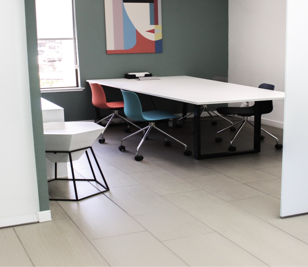 Evolved Medical meeting room with a white table, colourful chairs and abstract wall art