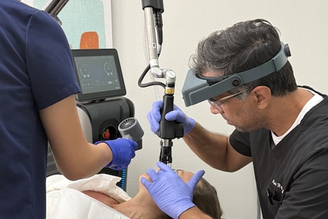 Dr. Rajguru performing a laser skin treatment with an assistant at Evolved Medical
